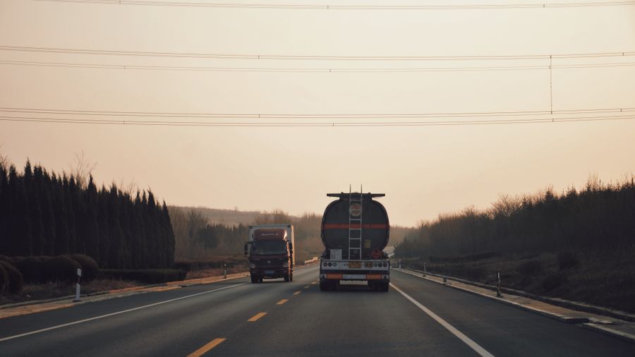 Long-haul trucks running a corridor route at sunset